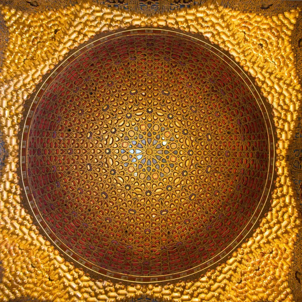 La coupole de bois doré du Salon des Ambassadeurs vue d'aplomb, son motif d'étoiles entrelacées rayonnant depuis le centre