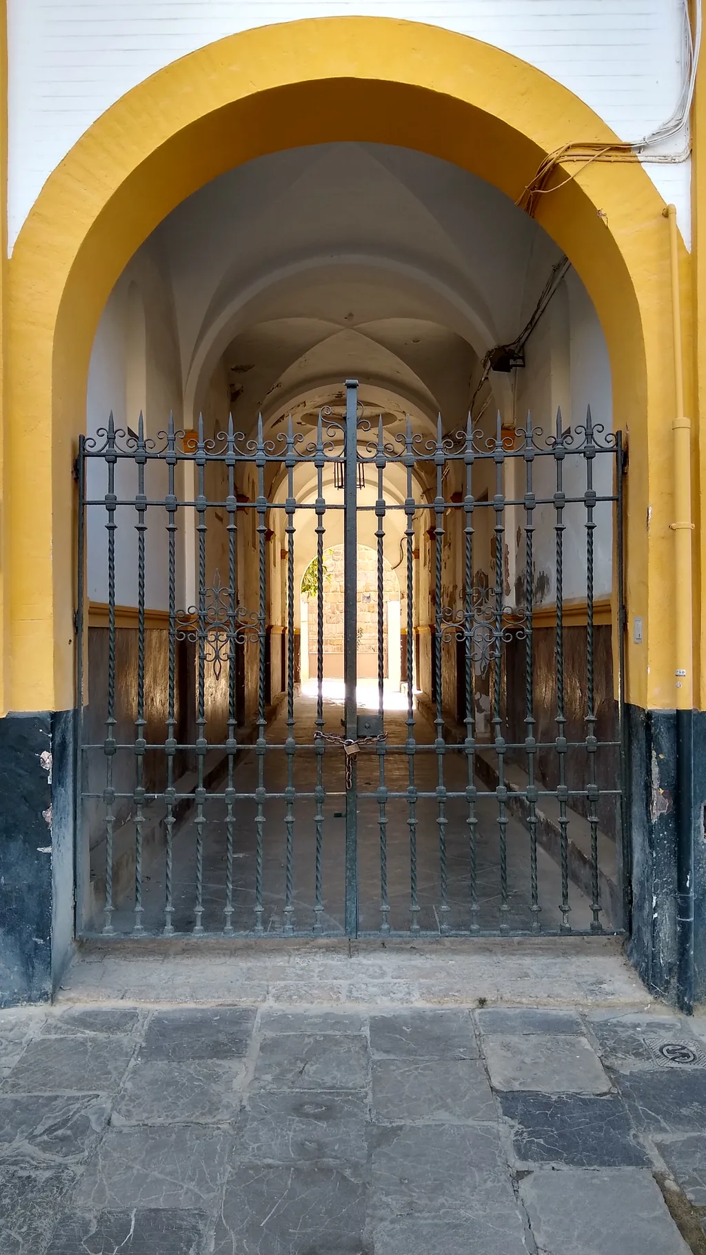 Ein schmaler gewölbter Durchgang aus dem Patio de Banderas hinaus