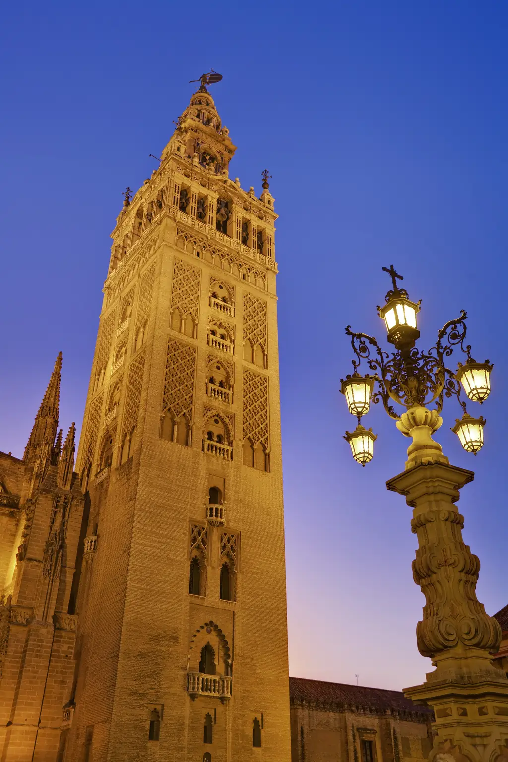 The Giralda bell tower of Seville Cathedral lit at dusk