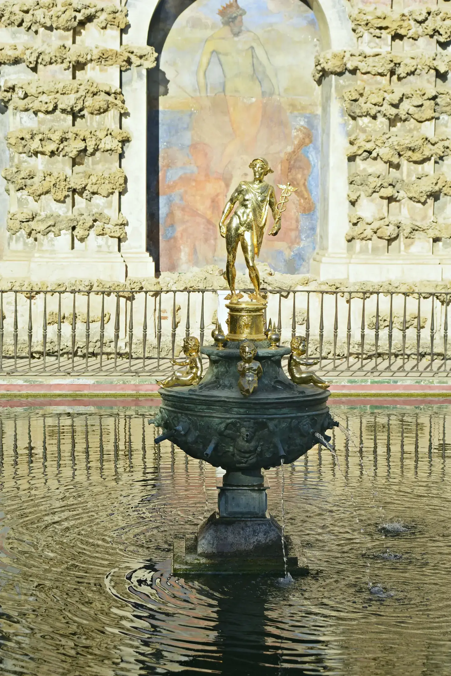 Der bronzene Merkurbrunnen aus der Nähe, auf seinem Becken vor der freskierten Nische