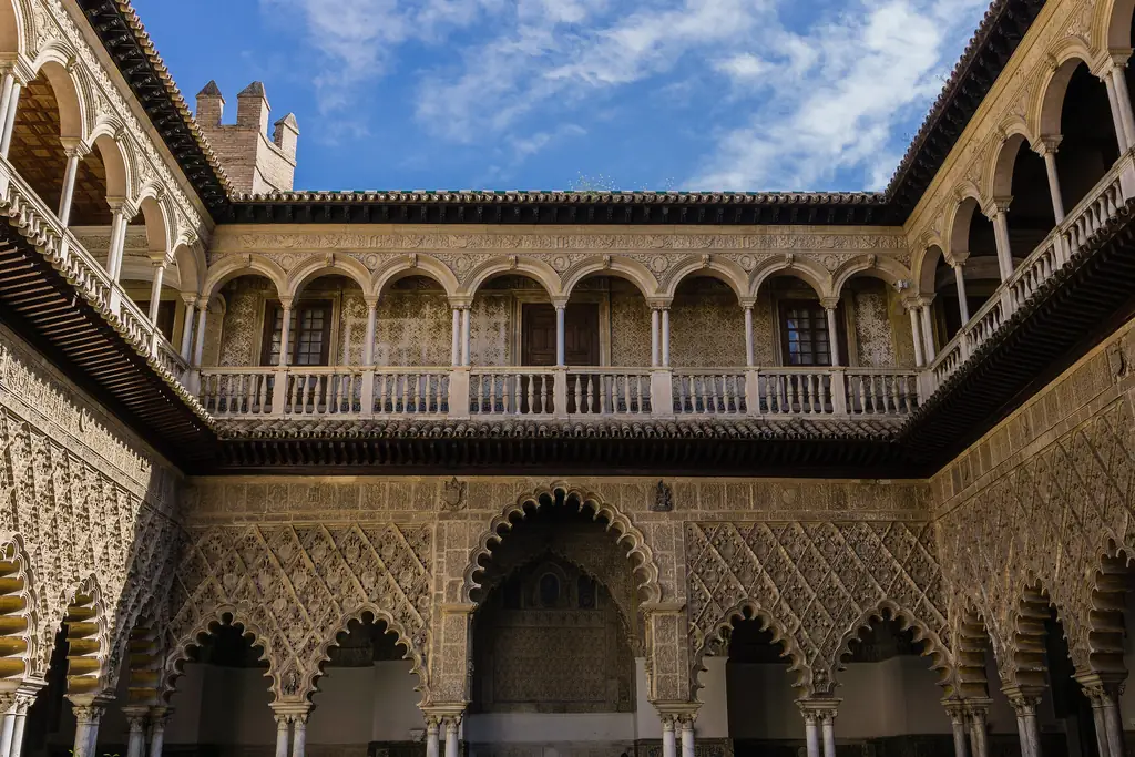 Carved plaster arches and the upper gallery around the Patio de las Doncellas