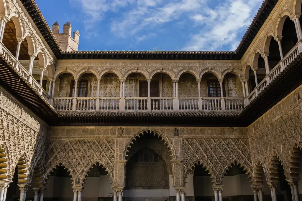 Geschnitzte Stuckarkade des Patio de las Doncellas, mit der Renaissance-Galerie über dem Mudéjar-Erdgeschoss